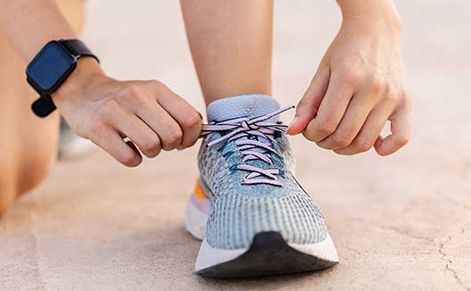 person tying running shoe