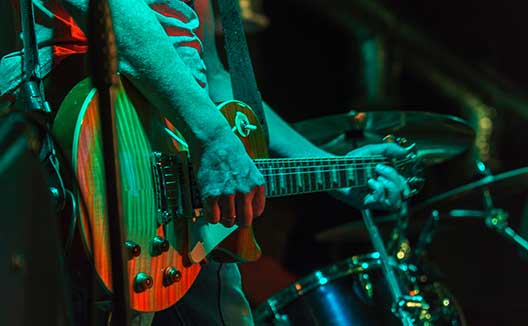 man playing guitar with drummer